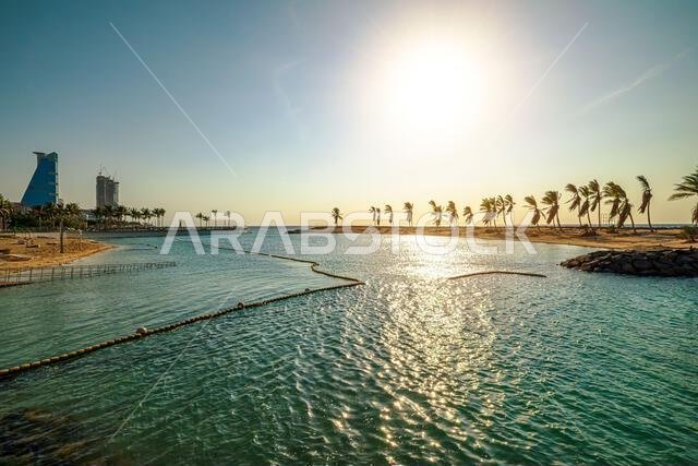 تتدحرج أمواج صغيرة برفق في مياه البحر الأحمر الزرقاء الداكنة، بينما ترسم الشمس الغاربة السماء بألوان برتقالية ووردية دافئة.