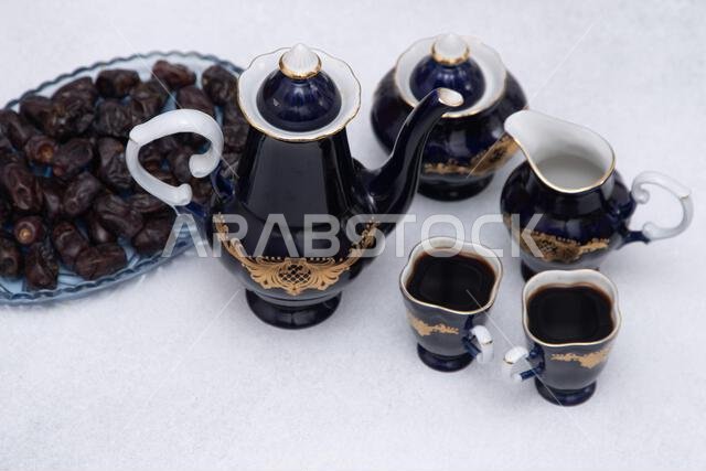 Coffee set with decanter, creamer, blue sugar bowl and two cups . Vintage tableware. Sweet dates fruit.