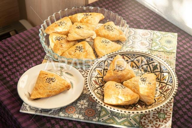 معجنات شرقية مالحة منزلية الصنع مع بذور السمسم الأسود والأبيض، منظر علوي. فطائر، منظر علوي. منظر من أعلى الطاولة