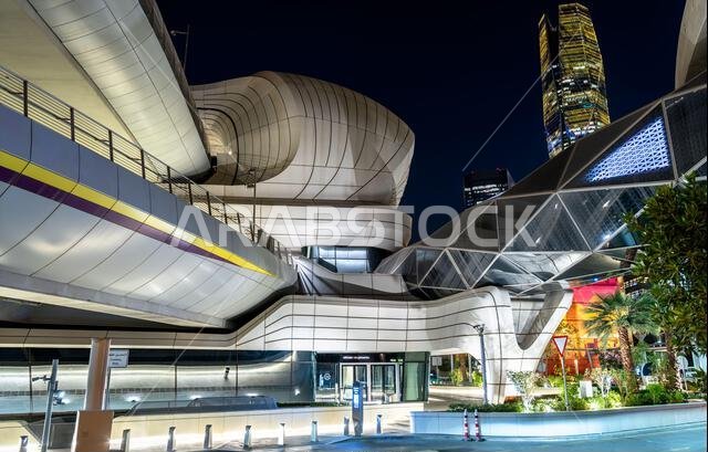 Riyadh, Saudi Arabia - February 19, 2026: The futuristic architecture of the King Abdullah Financial District Metro Station illuminated at night with skyscrapers in the background.