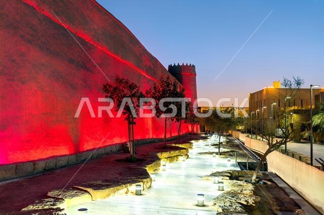 The historic Masmak Fortress wall illuminated with red lights at night in the Ad Dirah district of Riyadh, Saudi Arabia.