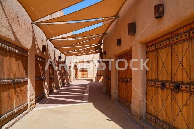 Traditional wooden shop doors and sun shade sails in an alley of Al Dho historical district, Riyadh, Saudi Arabia