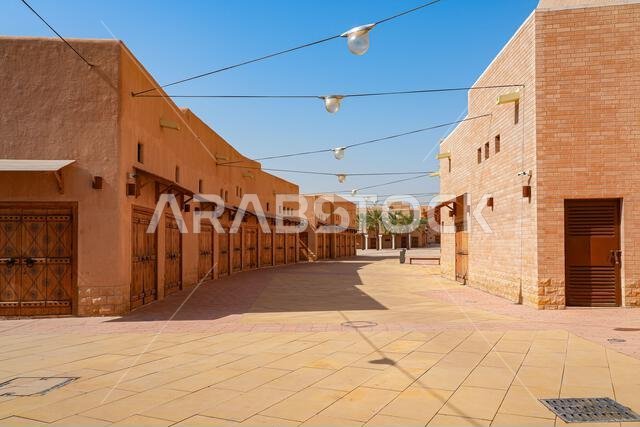 Wide pedestrian avenue with traditional mud brick shops and restored heritage buildings in Al Dho historical district, Riyadh, Saudi Arabia