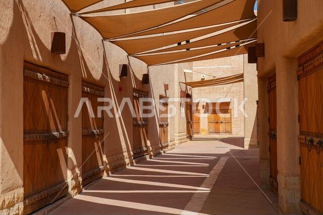 Traditional wooden shop doors and sun shade sails in an alley of Al Dho historical district, Riyadh, Saudi Arabia