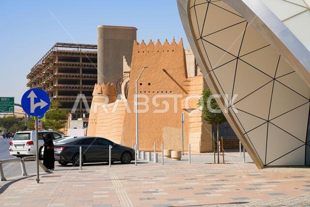 مدخل هندسي حديث لمحطة مترو مجمع المحاكم بجوار جدران الطوب اللبن التقليدية في حي الضو التاريخي، الرياض، المملكة العربية السعودية