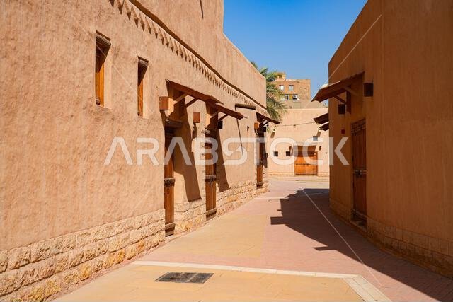 Narrow pedestrian alley with traditional Najdi mud brick buildings and carved wooden doors in Al Dho historical district, Riyadh, Saudi Arabia Narrow pedestrian alley with traditional Najdi mud brick buildings and carved wooden doors in Al Dho historical district, Riyadh, Saudi Arabia