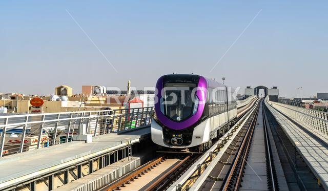 Riyadh, Saudi Arabia - February 21, 2026: A modern purple Riyadh Metro train travels along an elevated track through the Ishbiliyah district during the day