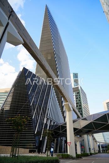 ناطحة سحاب هندسية مستقبلية، وجسر معلق، ومسار سكة حديدية مرتفعة في مركز الملك عبد الله المالي، الرياض، المملكة العربية السعودية