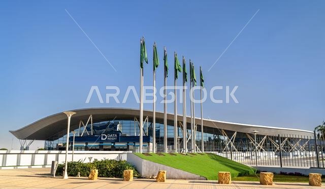 Riyadh, Saudi Arabia - February 21, 2026: The modern wave-shaped facade of the Riyadh International Convention and Exhibition Center with Saudi national flags flying in front.