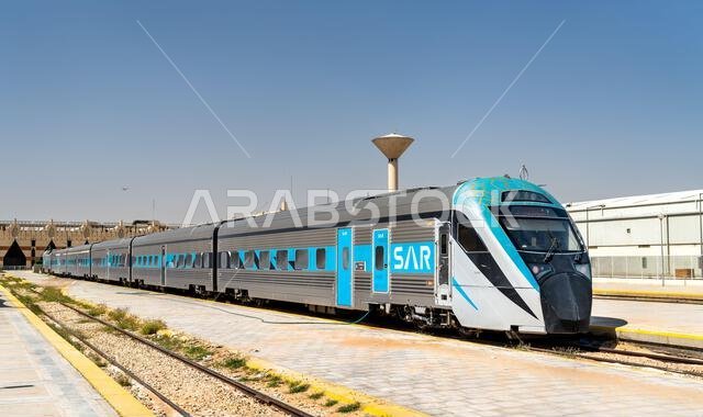 الرياض، المملكة العربية السعودية - ٢٢ فبراير ٢٠٢٦: قطار ركاب تابع لسكك حديد المملكة العربية السعودية متوقف على القضبان في محطة قطار الرياض تحت سماء زرقاء صافية