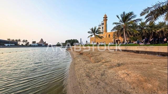Sandy beach and Abdul Qadir Faqih mosque and minaret on the waterfront promenade of Jeddah New Corniche, Saudi Arabia