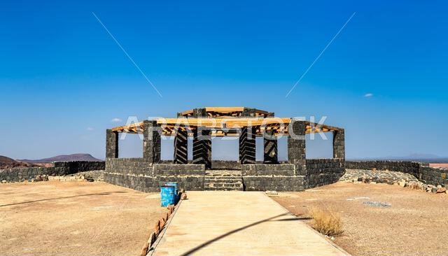 Stone and wood Wabah Crater Main View observation deck in Hafir Kishb, Saudi Arabia, under a clear blue sky