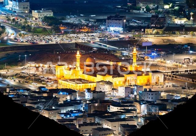 منظر جوي ليلي لمسجد سيد الشهداء المضاء وحركة المرور المحيطة به في المدينة المنورة، المملكة العربية السعودية.