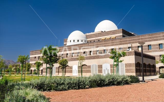 Modern architectural design of the Madinah Regional Municipality building featuring white domes and striped stone facade under a blue sky in Medina, Saudi Arabia.