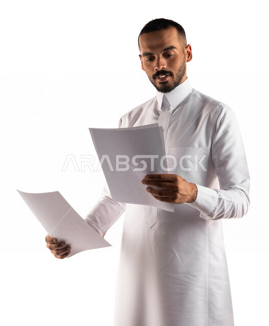 بورتريه لرجل عربي خليجي سعودي يحمل بيده مجموعة من الاوراق ، أوراق خاصة بالعمل ، بحث علمي ، قراءة الملاحظات والمعلومات ، متابعة الخطط والمشاريع  ، تدقيق الاوراق ، خلفية بيضاء 