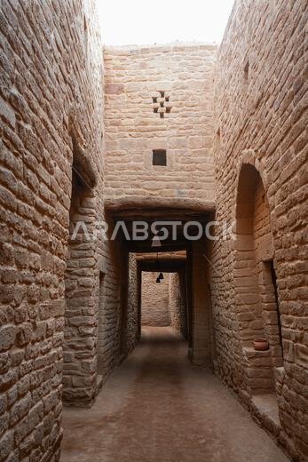Traditional covered alleyway with mudbrick walls in the historical site of AlUla Old Town, Saudi Arabia