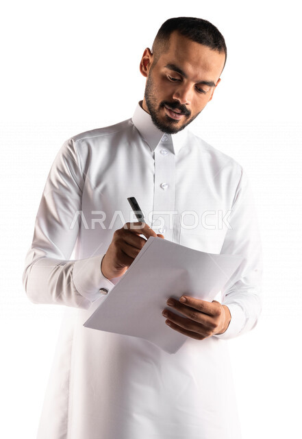بورتريه لرجل عربي خليجي سعودي يقوم بتدوين الملاحظات على الورق ، التخطيط للعمل ، توقيع عقد عمل ، تدوين نتائج الاجتماع ، اعداد تقارير ومهام العمل ، دراسة جدوى الاعمال ، خلفية بيضاء