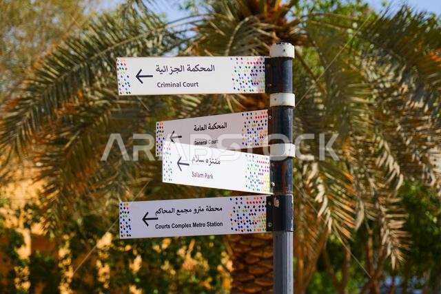 Bilingual directional street sign pointing to the Criminal Court and General Court in Riyadh, Saudi Arabia