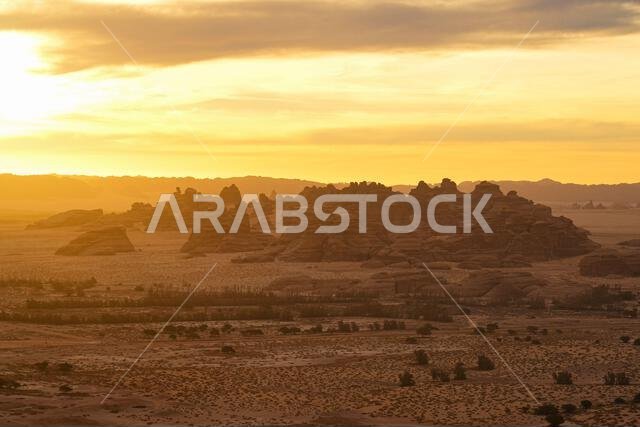 Aerial view of the sunrise over the sandstone rock formations in the ancient site of Hegra, AlUla