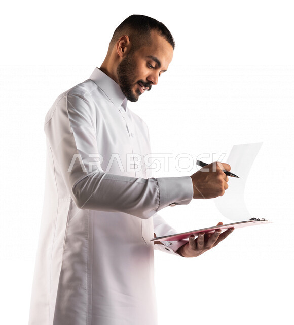بورتريه لرجل عربي خليجي سعودي يقوم بتدوين الملاحظات على اوراق و ملفات خاصة بالعمل ، التخطيط للعمل ، توقيع عقد عمل ، تدوين نتائج الاجتماع ، اعداد تقارير ومهام العمل ، دراسة جدوى الاعمال ، خلفية بيضاء