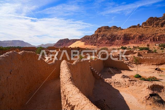 Traditional mudbrick wall path weaving through the lush green palm oasis in AlUla, Saudi Arabia