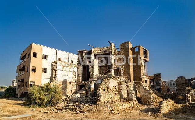 View of traditional coral stone buildings and ruins within the Yanbu Historic Area under a clear sky in Saudi Arabia.