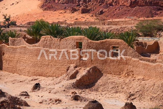 Ancient mudbrick ruins and lush green trees in the historical heritage oasis of AlUla, Saudi Arabia
