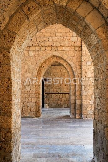منظور من خلال الأقواس الحجرية داخل بوابة باب مكة التاريخية في جدة، المملكة العربية السعودية