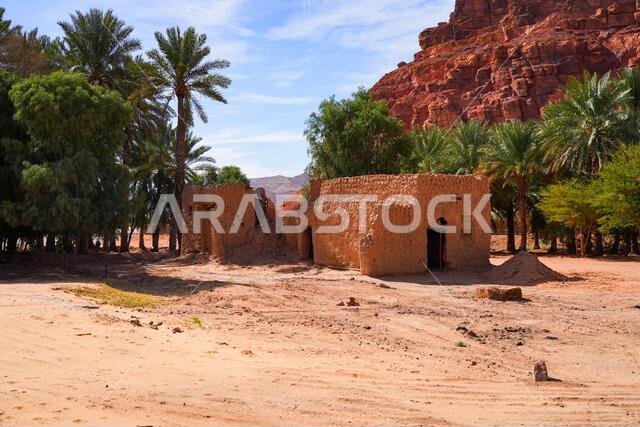 Ancient mudbrick ruins and lush green trees in the historical heritage oasis of AlUla, Saudi Arabia