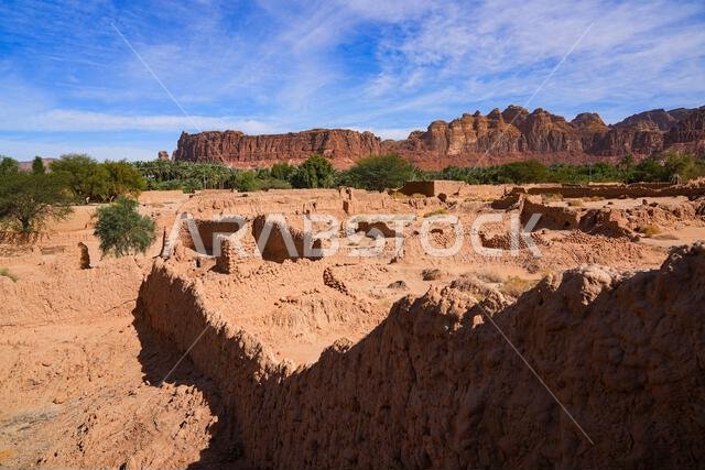Ancient mudbrick ruins against red sandstone mountains in the historical heritage oasis of AlUla, Saudi Arabia