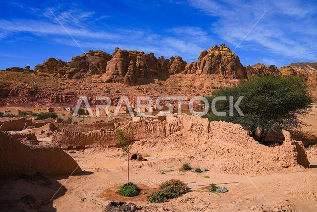 Ancient mudbrick ruins against red sandstone mountains in the historical heritage oasis of AlUla, Saudi Arabia