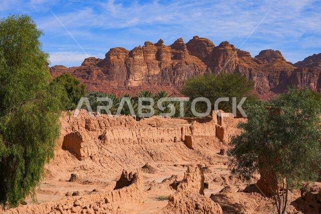Ancient mudbrick ruins and lush green trees in the historical heritage oasis of AlUla, Saudi Arabia