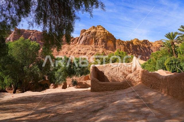 Ancient mudbrick ruins and lush green trees in the historical heritage oasis of AlUla, Saudi Arabia