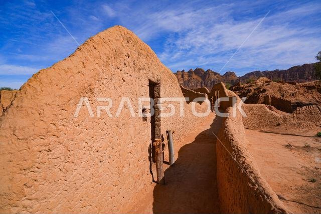 Traditional mudbrick wall path weaving through the lush green palm oasis in AlUla, Saudi Arabia