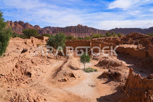Ancient mudbrick ruins and lush green trees in the historical heritage oasis of AlUla, Saudi Arabia