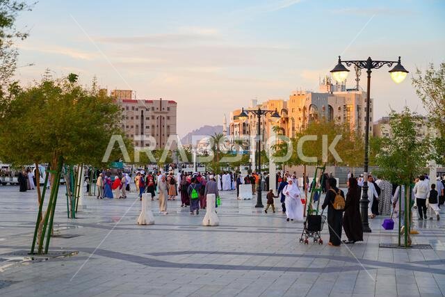 Vibrant crowd of pilgrims walking on the pedestrian Quba Square in the holy city of Madinah, Saudi Arabia