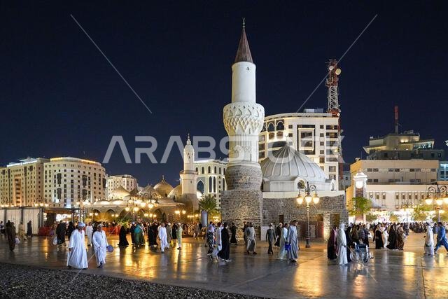 Night view of the historic Abu Bakr As-Siddiq Mosque and bustling plaza in Madinah, Saudi Arabia