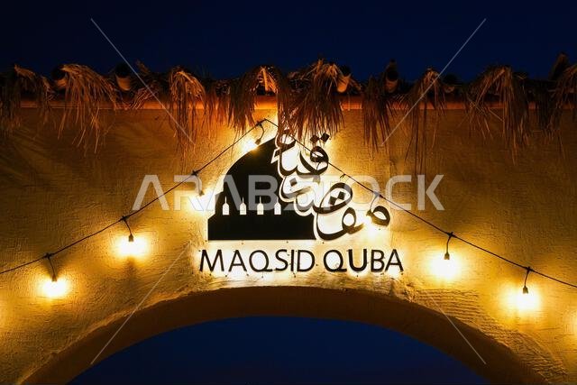 Illuminated Maqsid Quba signage and Arabic calligraphy at night in Madinah, Saudi Arabia