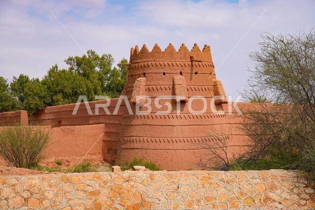 A traditional mud brick watchtower and defensive wall in the heritage village of Ushaiqer, Saudi Arabia