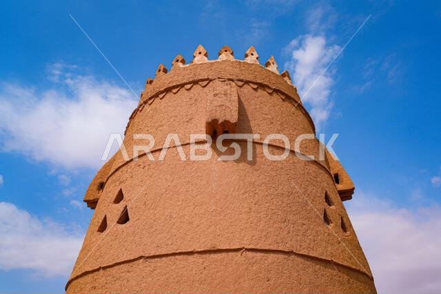 A traditional mud brick watchtower and defensive wall in the heritage village of Ushaiqer, Saudi Arabia