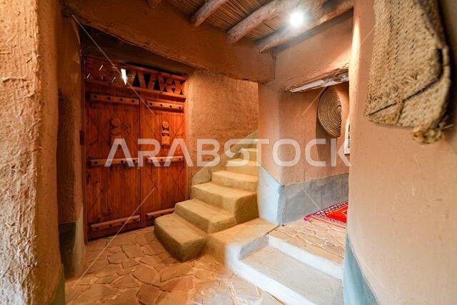 Mud brick staircase and wooden door inside the Home of Ibrahim ben Saleh Aleisa in Ushaiqer, Saudi Arabia