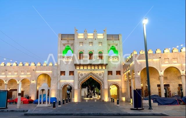 العمارة التقليدية المضاءة لمدخل سوق الحرفيين القيصرية في الهفوف، الأحساء، المملكة العربية السعودية عند الغسق.