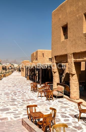 Traditional adobe architecture and outdoor seating along the stone paved street of AlUla Old Town in Saudi Arabia