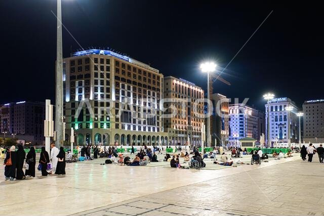 Pilgrims resting at night on the marble courtyard of Al-Masjid an-Nabawi in Madinah, Saudi Arabia