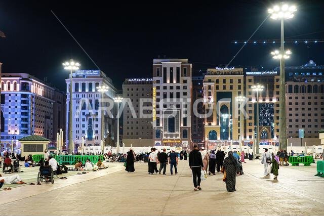 حجاج يستريحون ليلاً في ساحة المسجد النبوي الرخامية بالمدينة المنورة، المملكة العربية السعودية
