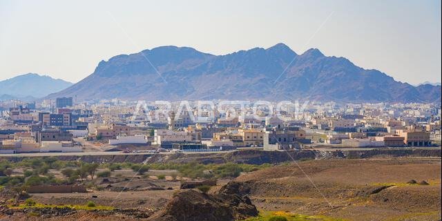 إطلالة بانورامية على الضواحي السكنية والمنازل في المدينة المنورة، الواقعة تحت سلسلة جبال مهيبة في المملكة العربية السعودية.
