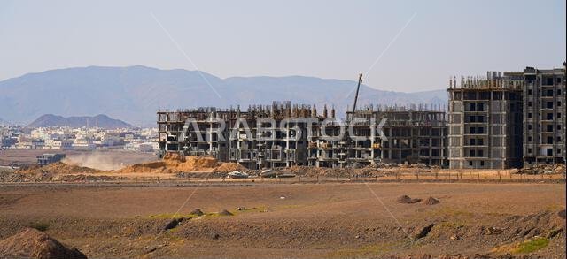 مبانٍ سكنية قيد الإنشاء في منطقة صحراوية تحيط بها الجبال في المدينة المنورة، المملكة العربية السعودية