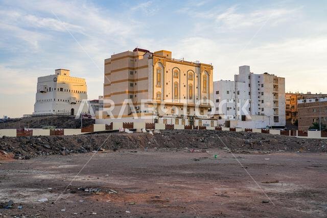 The historic Quba Castle on a rocky hill next to modern residential buildings in Madinah, Saudi Arabia