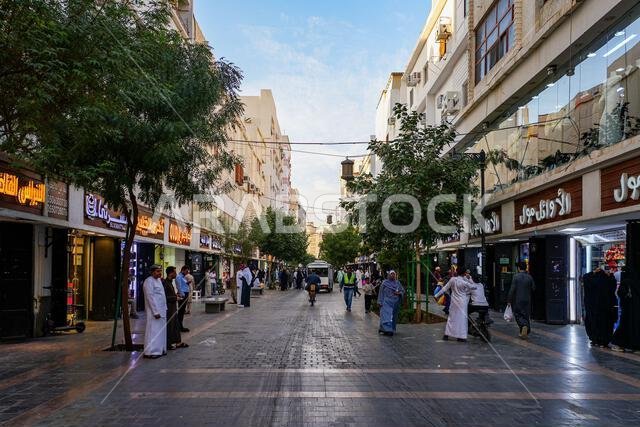 المشاة والمتاجر المحلية على طول شارع قباء المزدحم المخصص للمشاة في المدينة المنورة، المملكة العربية السعودية