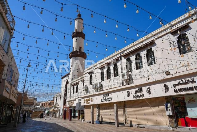 شارع للمشاة مزين بزخارف معلقة يؤدي إلى مسجد في منطقة البلد التاريخية بالطائف في المملكة العربية السعودية